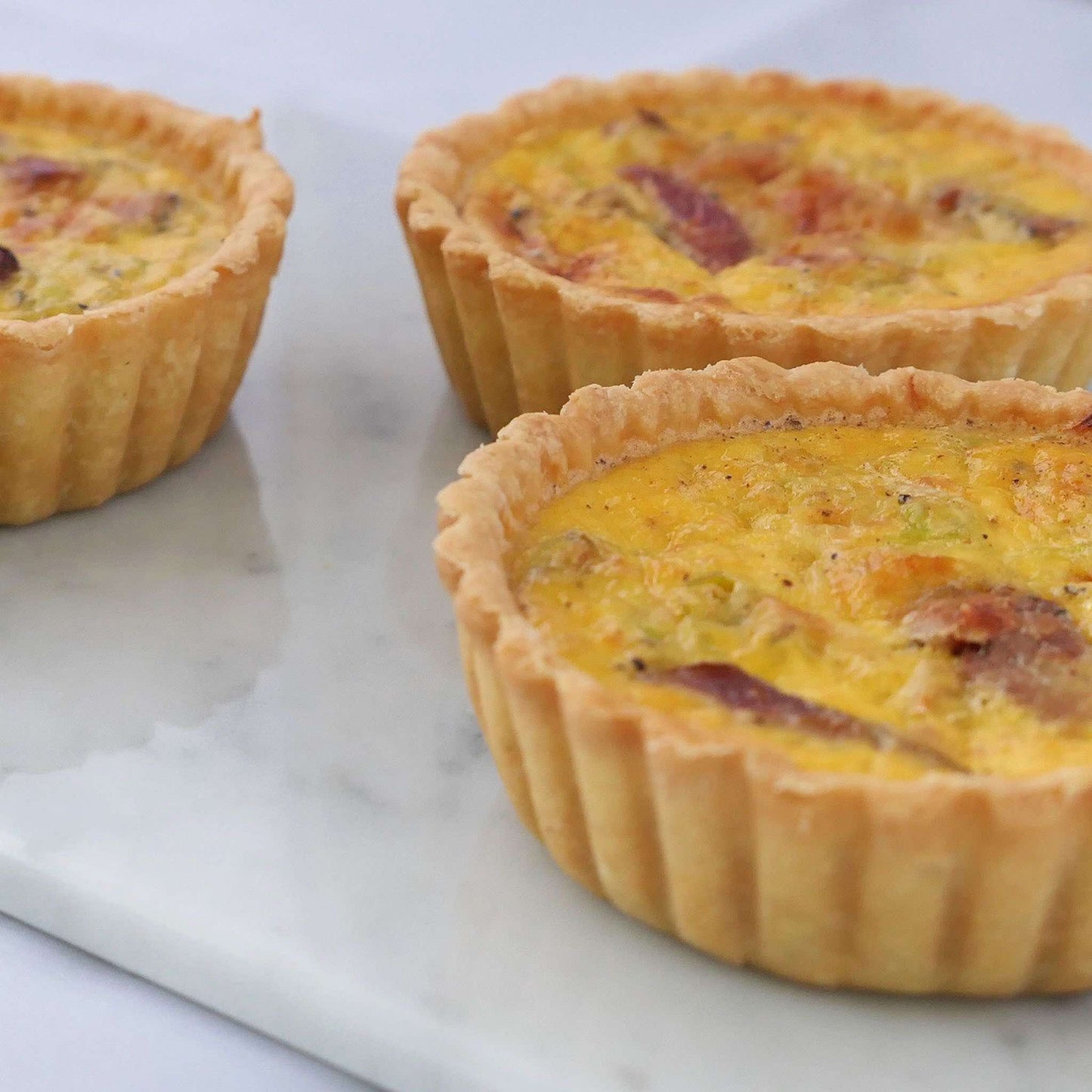 Lovely smoked duck, fragrant leeks and premium cheeses in an aromatic light custard, set in our signature thin crust. These are 10cm quiches.