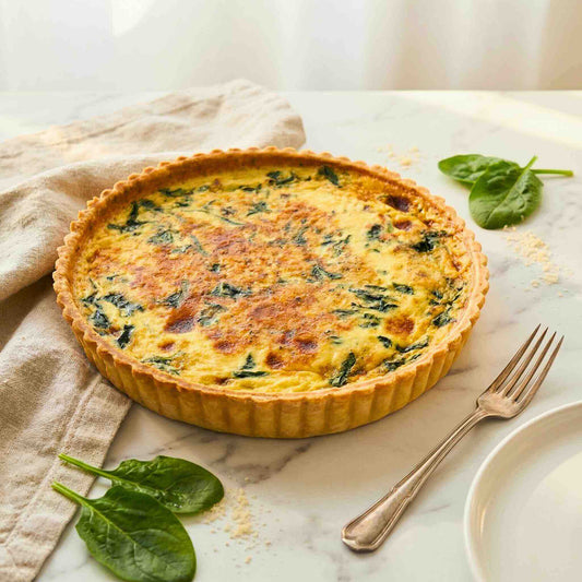 Family size 24cm Bacon Spinach quiche with golden buttery thin crust on marble surface, fresh spinach leaves and linen napkin | Carpina Bakery Singapore